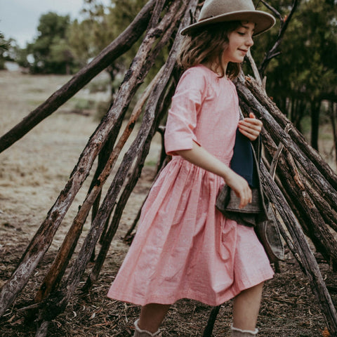 The Jackie dress is a classic shape, little gather at neck with a 3/4 sleeve with gathered on long skirt. It has buttons at the back. The print is sweet with lines and tiny shapes in red/orange on a cream cotton fabric.